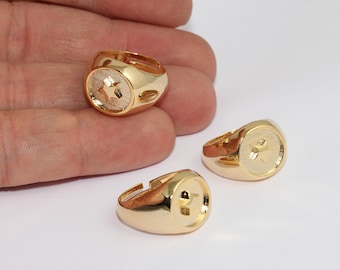 May include: Three gold-colored adjustable rings. Each ring features a round face with a textured background and a star design. The rings are displayed on a white surface. The rings are made of a shiny, gold-toned metal.