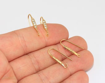 May include: Four gold-toned earring hooks featuring a slender, elongated bar design. Each hook is embellished with a row of four small, clear, sparkling stones set into the metal. The earring components have a curved wire back for secure attachment.