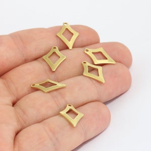 May include: Several small, gold-colored diamond-shaped charms with a cutout center and a small loop at the top for stringing. The charms are scattered on a white background, ideal for jewelry making or crafting.