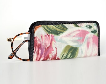 May include: A floral patterned glasses case with a black trim and a pair of tortoiseshell glasses with clear lenses. The glasses have the text "SILVER FRAME" printed on the side.