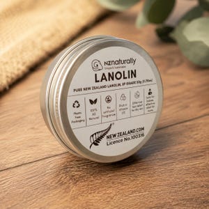 May include: A round, silver tin of "nzaturally" Lanolin, a skin care product. The label includes text about the product's features, such as being plastic-free, natural, and fragrance-free. The tin contains 20g (0.70oz) of lanolin.