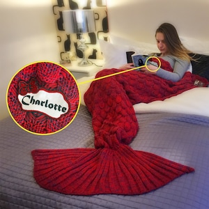 Puede incluir: Manta de cola de sirena de punto rojo con un parche personalizado que dice "Charlotte" en letras negras.