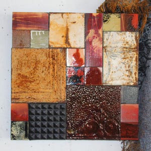May include: A square wall art piece made of various tiles in shades of brown, red, and black. The tiles are arranged in a geometric pattern, creating a unique and abstract design.