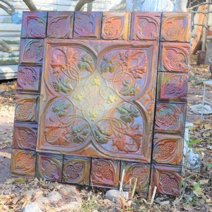 May include: A vintage iridescent tile with a geometric design of leaves and vines. The tile is made of ceramic and has a glossy finish. The tile is a beautiful example of Victorian era craftsmanship.
