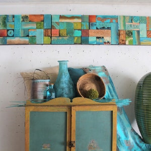 May include: A turquoise and gold cabinet with two doors, decorated with a mosaic tile wall art above. The cabinet is decorated with a turquoise and gold paint finish. The mosaic tile wall art is made of various shades of blue, green, and brown tiles.