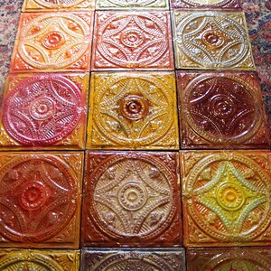May include: A close-up of a tiled floor with a repeating pattern of ornate, circular designs. The tiles are a mix of red, orange, yellow, and brown.