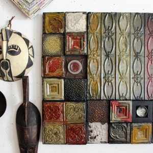 May include: A wall art piece made of a mosaic of small, square tiles. The tiles are in various shades of green, brown, red, and white. Some tiles have a textured surface, while others have a smooth surface. The tiles are arranged in a grid pattern.