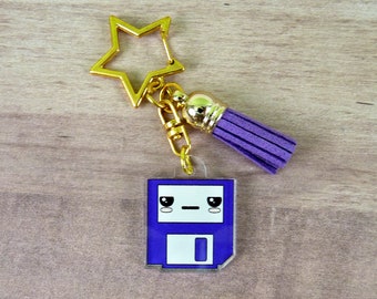 May include: Purple floppy disk charm with a cute cartoon face, attached to a gold star-shaped keychain with a purple tassel.