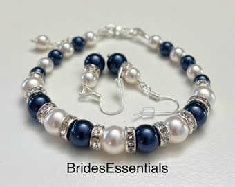 May include: A set of navy blue and white pearl jewelry with crystal accents. The set includes a bracelet and a pair of earrings. BridesEssentials is printed below the jewelry.