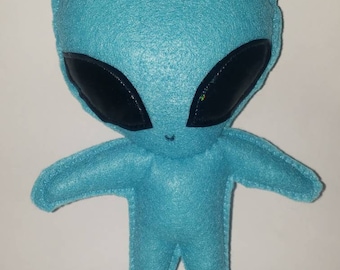 Peluche chibi de alienígena color verde azulado, estilo kawaii.