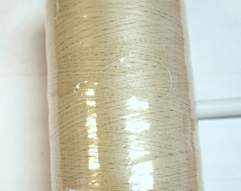 May include: A spool of off-white thread wrapped in clear plastic with a blue plastic cap.