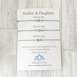 May include: A set of three blue friendship bracelets with silver star charms. The card reads "Mother & Daughters" and includes the text "One for Me", "One for You", "One for You", "Mums are hearts and daughters a star, To carry them with you wherever you are", "Meaningful Charm", and "www.meaningfulcharm.co.uk".