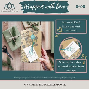 May include: A rectangular gift box wrapped in brown kraft paper with a black butterfly and floral pattern. The box is tied with teal cord and features a white gift tag with the text "lovely gift for you" and a small teal circular sticker.