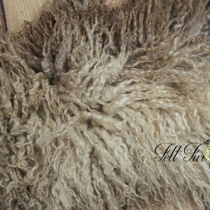 May include: Close-up of a sheepskin pelt with a dense, curly texture. The wool is a mix of light and dark brown tones, creating a natural, textured appearance. The words "Felt Fur" are visible in the lower right corner.