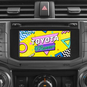 May include: A car dashboard with a screen displaying a retro-style graphic with the text "TOYOTA 4Runner" in a yellow, pink, and blue color scheme.
