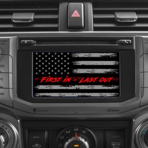 May include: A black and white distressed American flag with a red stripe and the text "FIRST IN = LAST OUT" on a car dashboard.