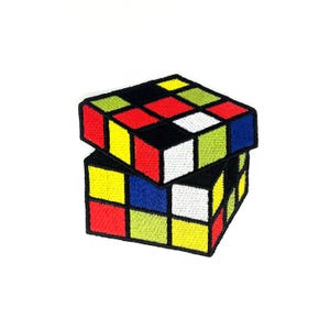 May include: Two embroidered patches in the shape of a Rubik's Cube, one stacked on top of the other. The cubes feature the classic color scheme of red, blue, yellow, green, white, and black. The patches have a black border.