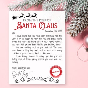 May include: A personalized letter from Santa Claus, featuring the text "FROM THE DESK OF SANTA CLAUS" in red. The letter is addressed to Ella and dated December 21st, 2022. The letter is decorated with a reindeer sleigh illustration.