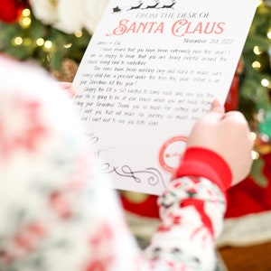 May include: A letter from Santa Claus, dated November 21st, 2022, with a red and black design. The letter is held by a person wearing Christmas pajamas, in front of a decorated Christmas tree.