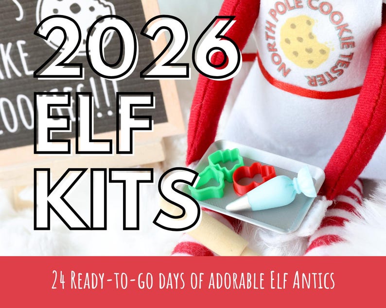 May include: A plush elf doll wearing a white apron with the text NORTH POLE COOKIE TESTER and a cookie graphic. The elf holds a small grey tray containing two green cookie cutters, one red cookie cutter, and a light blue icing piping bag.