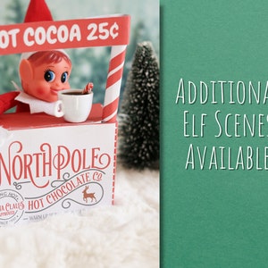 May include: A red and white elf-themed hot cocoa stand with a sign that reads "HOT COCOA 25&cent;". An elf is holding a cup of cocoa and a candy cane. The stand has a sign that says "NORTH POLE HOT CHOCOLATE CO."