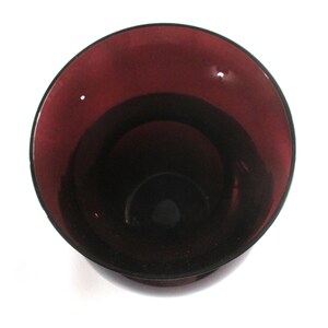 May include: A deep purple glass vase with a wide mouth and a rounded bottom.
