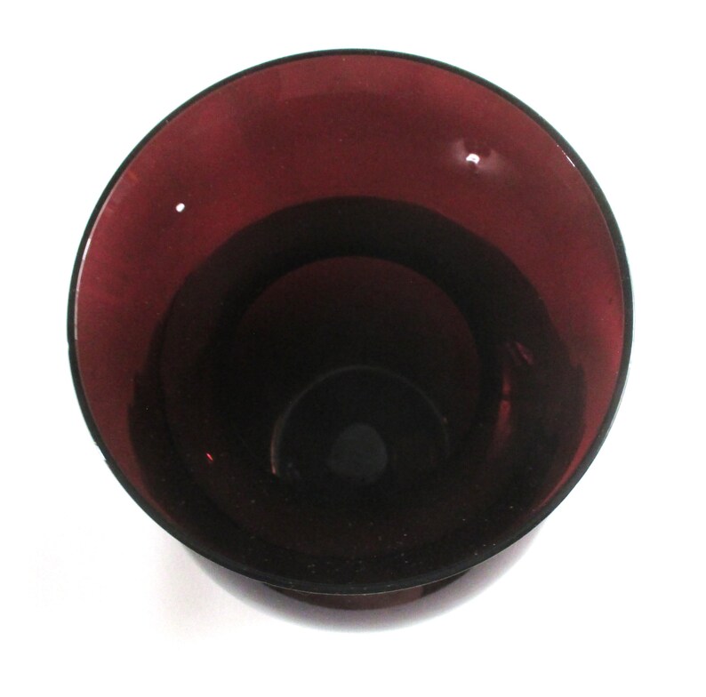 May include: A deep purple glass vase with a wide mouth and a rounded bottom.
