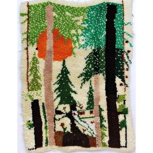 Op de afbeelding: Een vintage tapijt met een bos scène. Het tapijt is gemaakt van wol en heeft bomen, een zon en een huis. De kleuren zijn groen, bruin, oranje en wit.