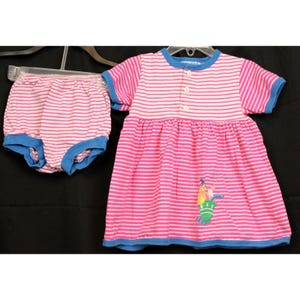 May include: A pink and white striped dress with a blue trim and a cartoon character on the front. The dress is paired with a pink and white striped diaper cover with a blue trim.