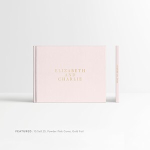 May include: A blush pink hardcover photo album with gold foil lettering that reads "ELIZABETH AND CHARLIE" and "AUGUST 26, 2023". The album is 10.5 inches by 8.25 inches.