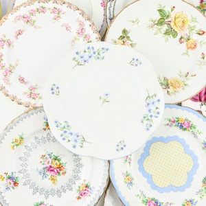 May include: A collection of vintage floral patterned china plates in various colours and designs. The plates are white with delicate floral patterns in shades of pink, blue, yellow, and green.