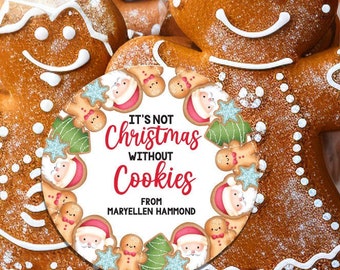 May include: A round gift tag with a festive Christmas design featuring gingerbread men, Santa Claus, and a wreath. The tag reads "It's not Christmas without Cookies" and "From Maryellen Hammond".