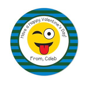 Op de afbeelding: Een ronde sticker met blauwe en groene strepen. De sticker heeft een geel smiley-gezicht met een tong die uitsteekt en één oog dicht. De tekst op de sticker luidt "Have a Happy Valentine's Day! From, Caleb".