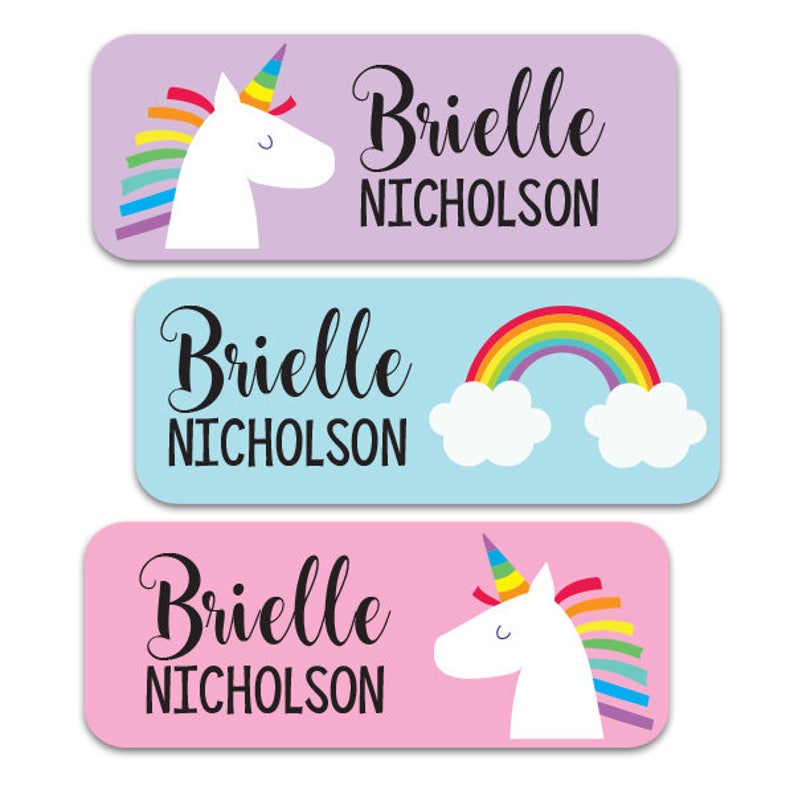 May include: Three colorful personalized name labels featuring a unicorn, a rainbow, and a unicorn. The labels are pink, blue, and pink and feature the name "Brielle Nicholson" in black cursive font.