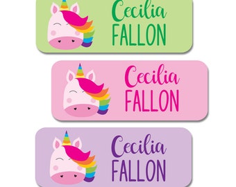 May include: Three rectangular labels with unicorn designs. Each label features a unicorn head with a rainbow mane and horn. The labels are in pastel green, pink, and purple, with the name "Cecilia Fallon" in a matching color.