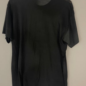 May include: A black short-sleeved t-shirt with a crew neck.