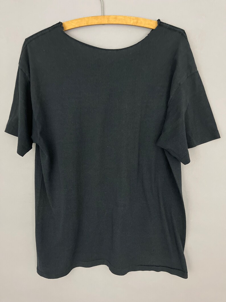 May include: Black short-sleeved t-shirt with a crew neck.