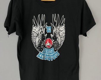 May include: Black t-shirt with a graphic of a motorcycle with wings and the text "'82 Harley Rendezvous".