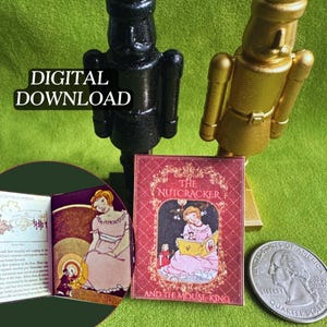 Pode incluir: Uma figura de quebra-nozes preta e dourada com um livro em miniatura intitulado "The Nutcracker and the Mouse King". O livro é vermelho com uma imagem de uma menina lendo. O texto "DIGITAL DOWNLOAD" também é visível.