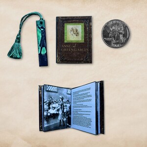 May include: Miniature book and bookmark set featuring the novel "Anne of Green Gables." The book is brown with gold lettering and a green square with a portrait. The bookmark has a green tassel and a silhouette. A quarter is next to the book.