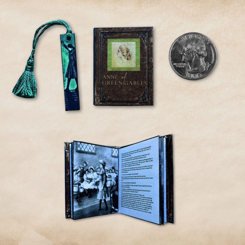May include: Miniature book and bookmark set featuring the novel "Anne of Green Gables." The book is brown with gold lettering and a green square with a portrait. The bookmark has a green tassel and a silhouette. A quarter is next to the book.