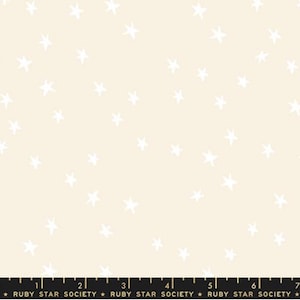 May include: Cream-colored fabric with a repeating pattern of white, hand-drawn stars. The stars are scattered across the surface. The bottom of the fabric has the text "RUBY STAR SOCIETY".