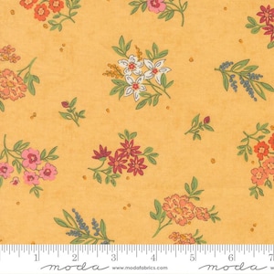 May include: A golden yellow fabric featuring a repeating floral pattern with clusters of small flowers in shades of pink, orange, red, and white, accented by green leaves and stems, with a white ruler showing 7 inches at the bottom edge.