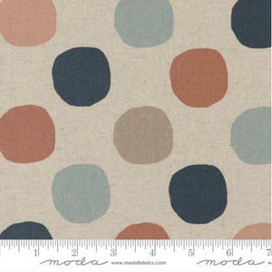 May include: A fabric with a repeating pattern of large, irregular circles in shades of coral, navy, light blue, and tan. The circles are scattered across a neutral, textured background. A ruler is at the bottom.