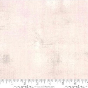 May include: A white fabric with a subtle pink and gray distressed pattern. The fabric has a soft, textured feel and is perfect for quilting, crafts, and home decor projects.