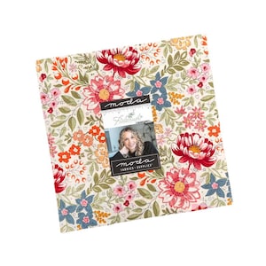 May include: A square stack of fabric squares featuring a floral pattern with red, pink, orange, and blue flowers on a cream background. A label on the front displays the text "moda", "Fieldrush", and "moda FABRICS + SUPPLIES" with a photo of a person.