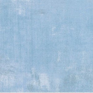 May include: A light blue fabric with a distressed, textured appearance. The fabric has a mottled effect with lighter areas, creating a vintage or worn look. The overall color is a soft, muted blue.