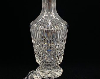 May include: A clear glass decanter with a diamond pattern and a matching stopper. The decanter has a tall, slender body and a wide base.