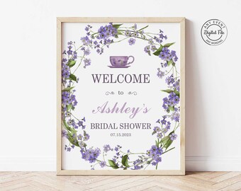 Puede incluir: Un cartel de bienvenida imprimible para una despedida de soltera con una corona de flores moradas, una taza de té y el texto "Bienvenido a Ashley's Bridal Shower 07.15.2023".