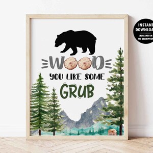 Könnte beinhalten: Ein druckbares Schild mit einer schwarzen Bärensilhouette und dem Text "Wood you like some grub" in einer Waldlandschaft mit grünen Bäumen und Bergen.